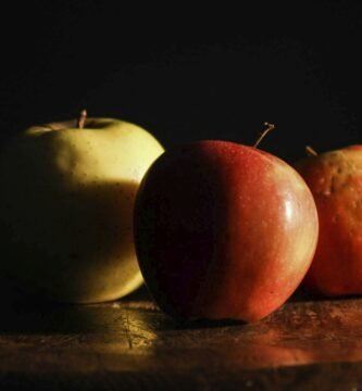 three apples sitting on top of a wooden table